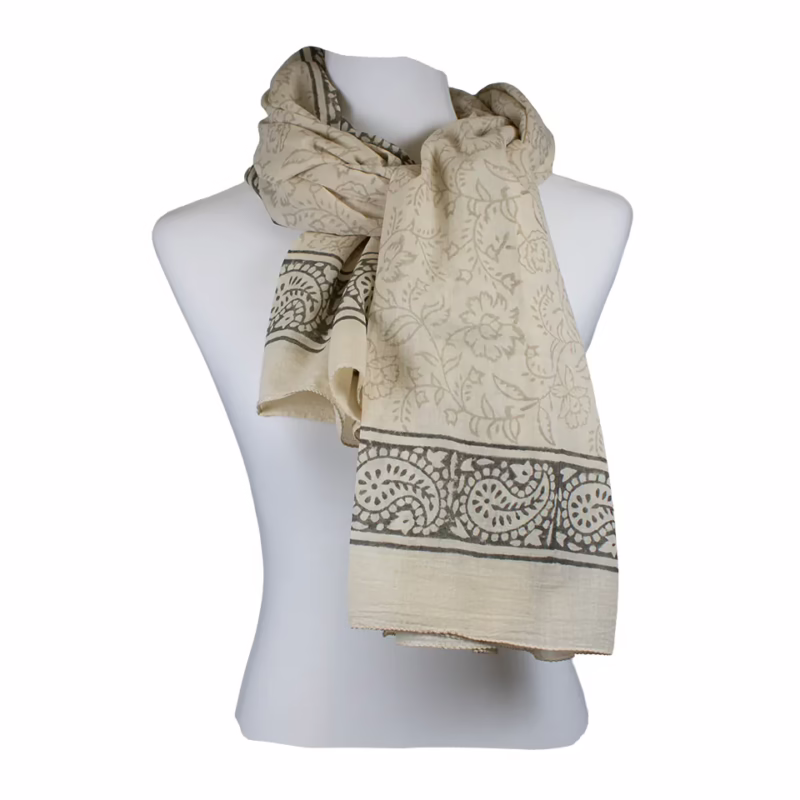 Schal in hellem Creme- und Beigeton mit feinem Allover-Ornamentmuster. Florale und grafische Motive gleichmäßig über die Fläche verteilt. Deutlich abgesetzte Bordüren in Schwarz mit ornamentalen Linien an den Seiten und Enden. Keine Fransen sichtbar.