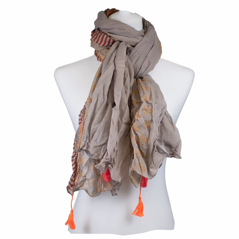 chal in taupe- und graubeigen Farbtönen mit feinen, unregelmäßig verteilten Ornamentmotiven in Gold. Längs verlaufende Musterbahnen mit ruhiger Flächenwirkung. Seitliche Bordüren mit schmalen Streifen in Pink und Gelb. Abschlüsse mit sichtbaren Quasten in Pink und Orange.