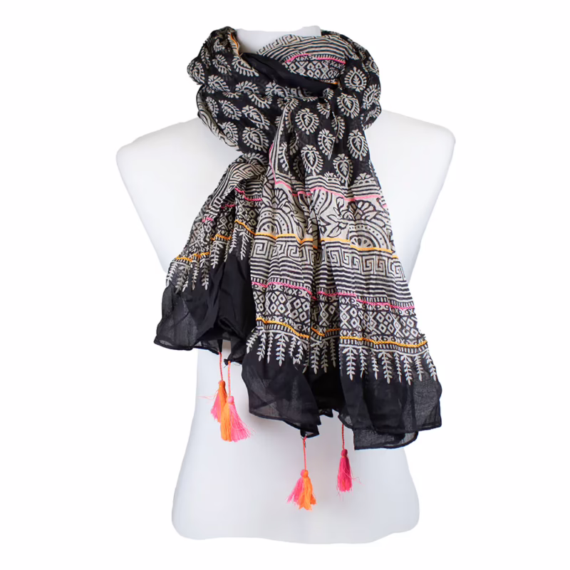 Langer Schal in Schwarz mit weißen grafischen Mustern, breiten Bordüren, feinen Stickereien und kurzen Quasten in Kontrastfarben.