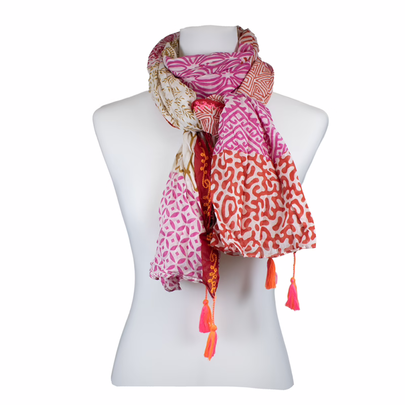 Mehrfarbiger Schal mit unterschiedlichen Musterzonen in Pink, Creme und Beige. Kombination aus kleinen grafischen Formen, Punktornamenten und linienartigen Mustern in horizontal gegliederten Abschnitten. Wiederholende Motive entlang der Länge. Sichtbare Quasten in Pink an den Enden.